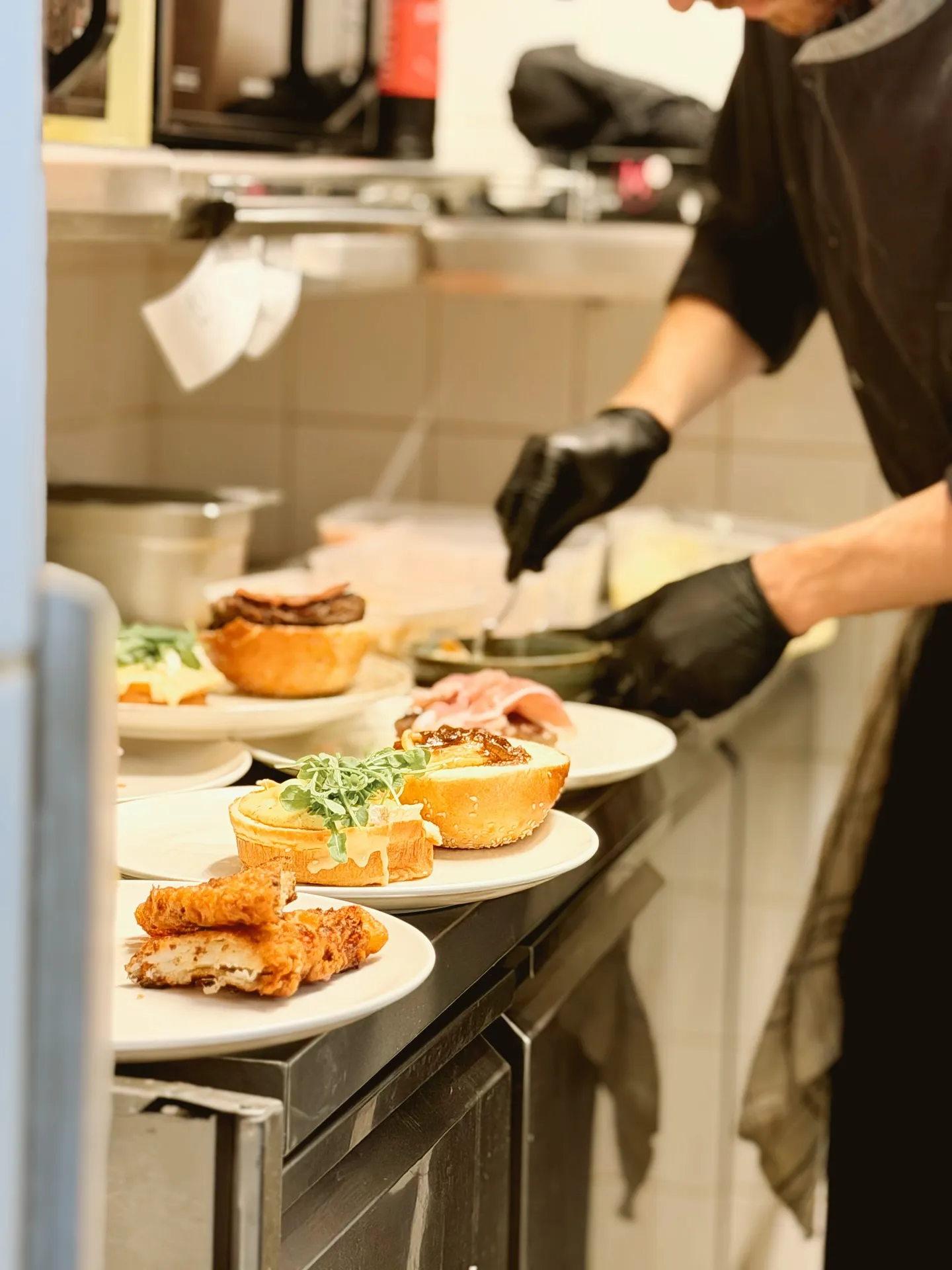 Préparation des plats en cuisine, mains gantées dressant les assiettes